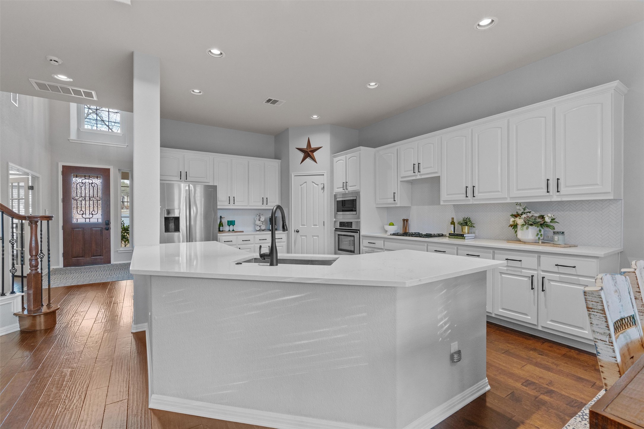3736 Cerulean Way Round Rock, TX 78681 - Photo 3 of 36 Kitchen with white cabinets, stainless steel appliances, a spacious island, recessed lighting, and dark wood finished floors