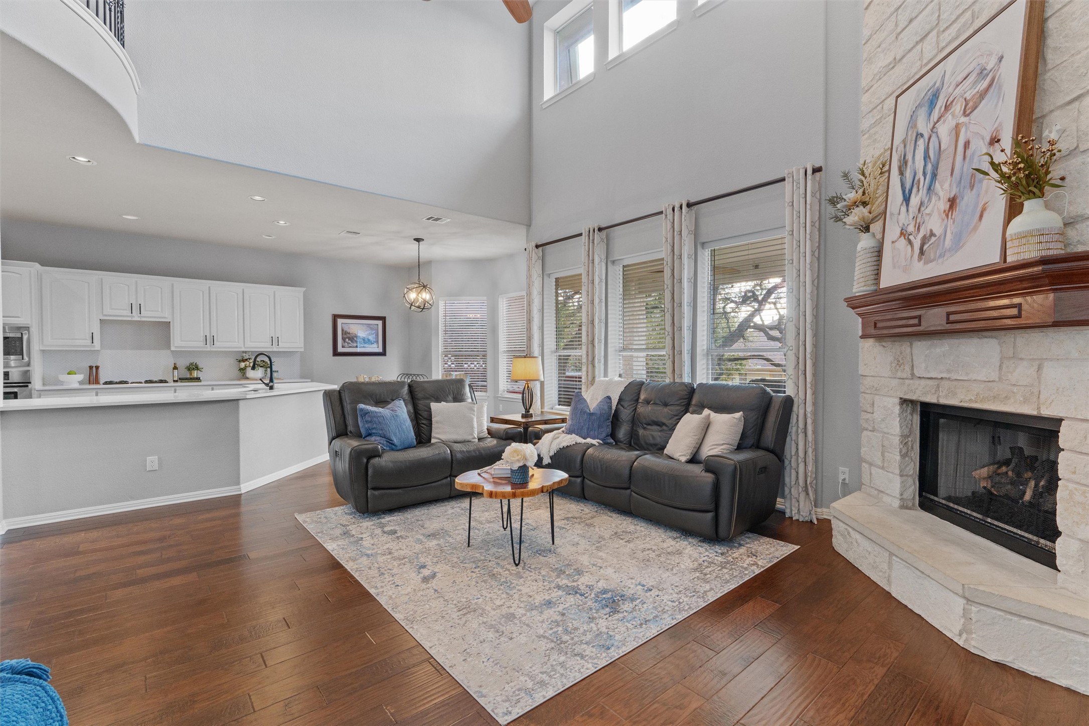 3736 Cerulean Way Round Rock, TX 78681 - Photo 9 of 36 Living room featuring a fireplace, dark wood-type flooring, healthy amount of natural light, a high ceiling, and recessed lighting