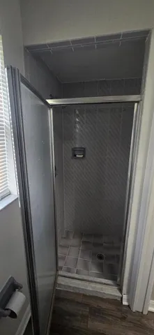 a toilet sitting in a bathroom next to a wooden floor