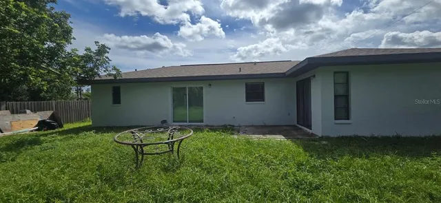 a backyard of a house with table and chairs