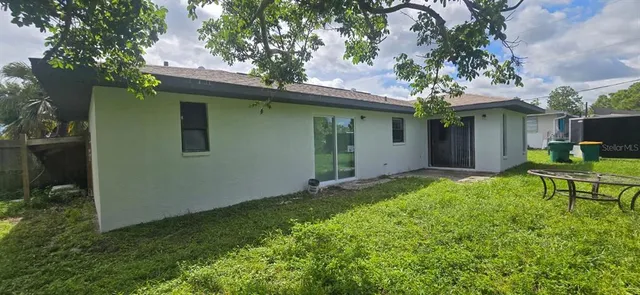 a backyard of a house with table and chairs
