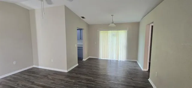 an empty room with wooden floor and a window
