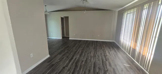 an empty room with wooden floor and a window