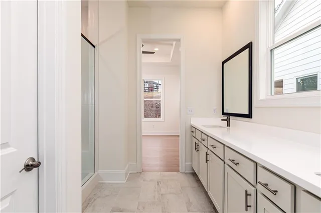 a spacious bathroom with a double vanity sink a mirror and a