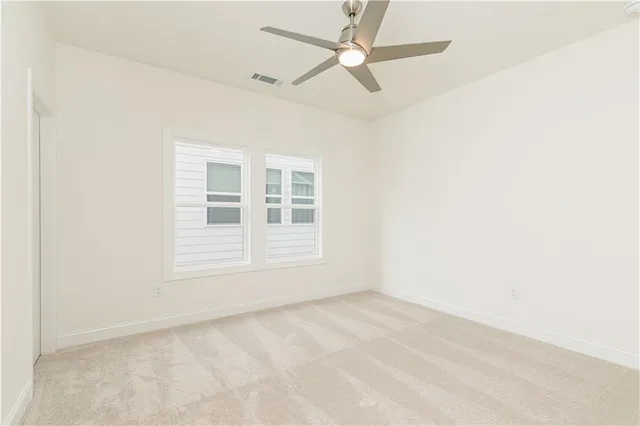 an empty room with a window and ceiling fan
