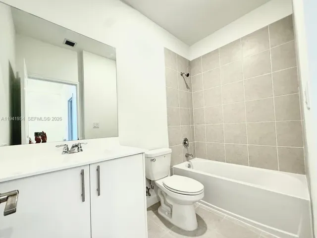 a white toilet sitting next to a white wall