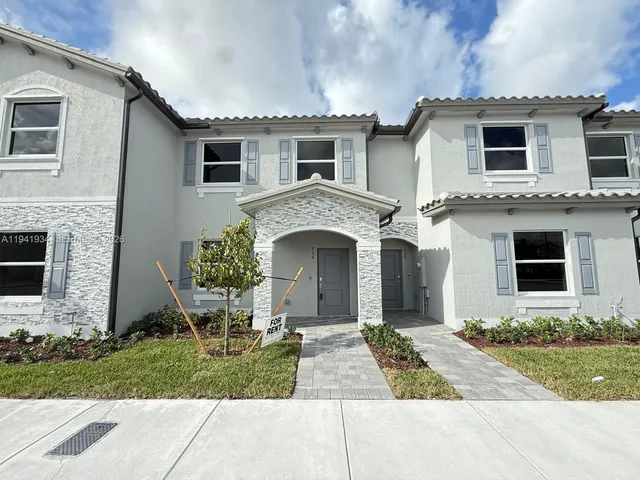 a front view of a house with a garden and plants