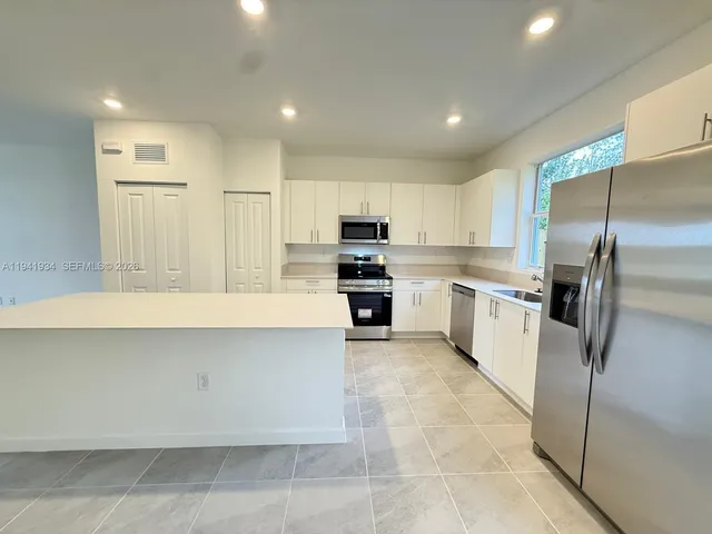 a kitchen with stainless steel appliances a refrigerator sink and microwave