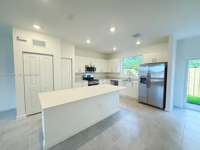 a large kitchen with a large counter top appliances and cabinets