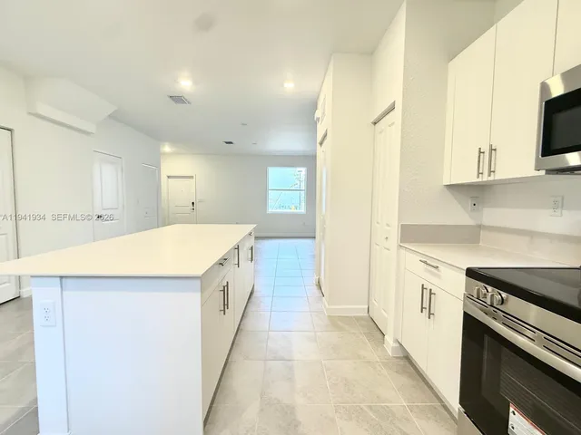 a view of a kitchen with a sink and dishwasher a stove top oven with wooden floor