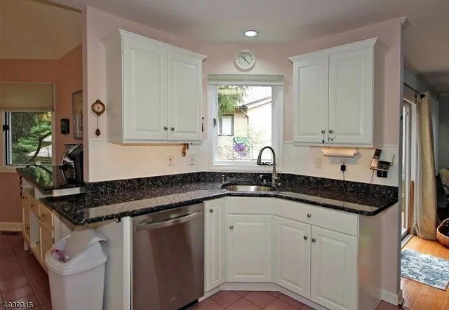 a kitchen with granite countertop a sink and cabinets