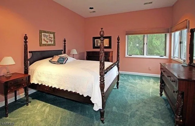 a bed sitting in a bedroom next to a window