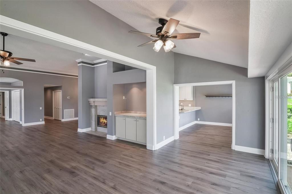 6036 Topsail Road Lady Lake, FL 32159 - Photo 15 of 35 a view of a livingroom with wooden floor and a ceiling fan