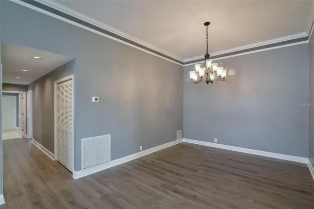 a view of a chandelier in big room and wooden floor