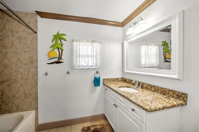 a bathroom with a granite countertop sink and a window