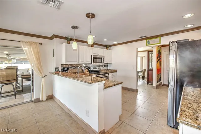 a kitchen with stainless steel appliances granite countertop a refrigerator and a stove top oven