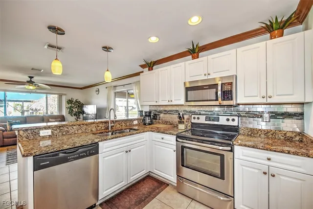 a kitchen with stainless steel appliances granite countertop a sink and cabinets with wooden floor