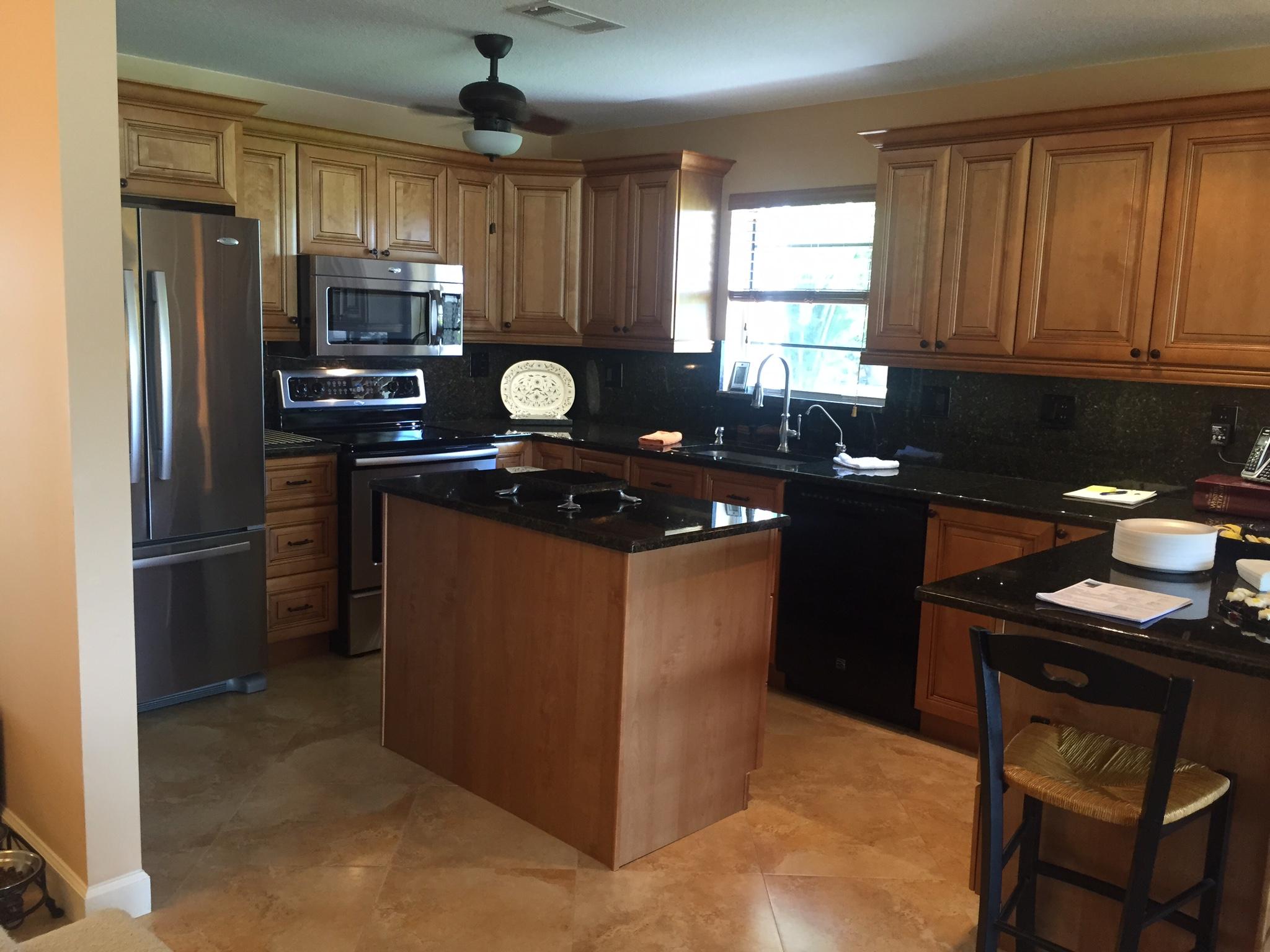 8904 Southwest 22nd Street, Unit H Boca Raton, FL 33433 - Photo 5 of 30 a kitchen with kitchen island granite countertop a sink stove and refrigerator