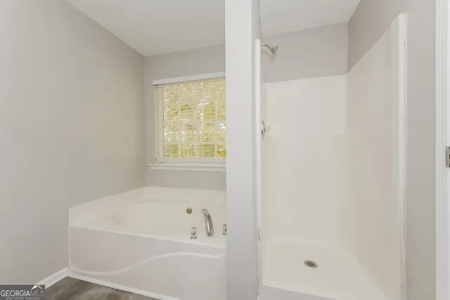 a white bath tub sitting next to a shower