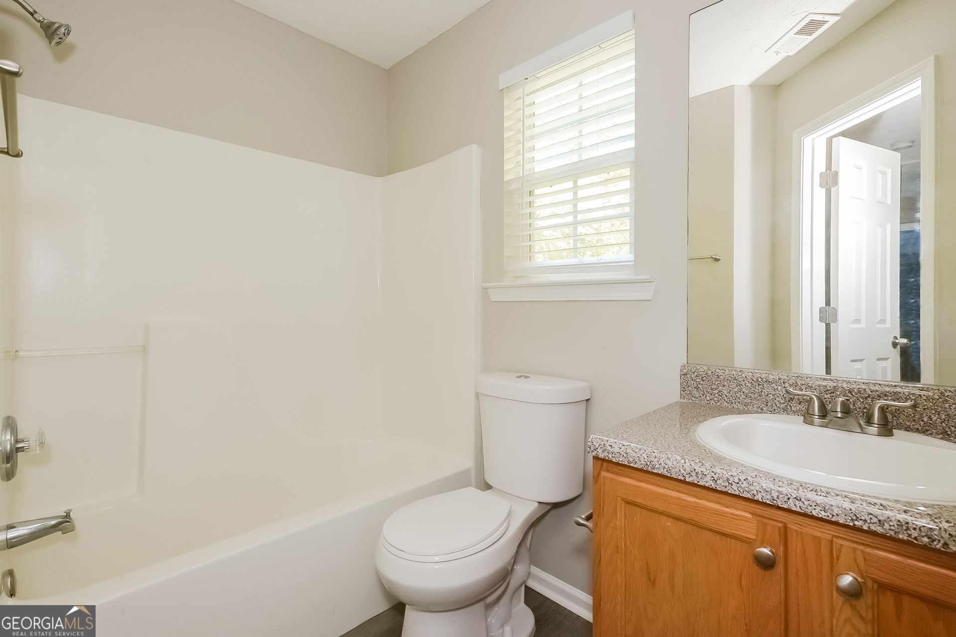 405 Hawthorne Circle Stockbridge, GA 30281 - Photo 14 of 17 a bathroom with a granite countertop toilet a sink and a mirror