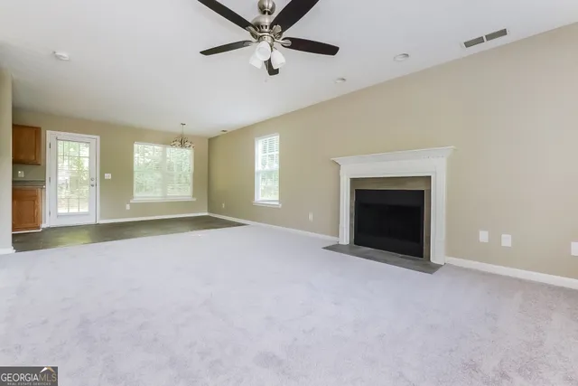 an empty room with windows and fireplace