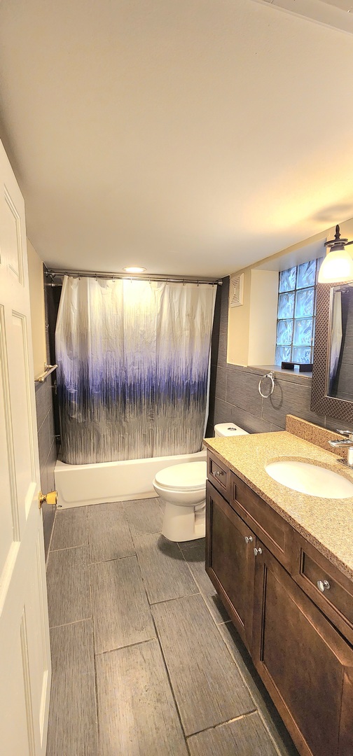 2948 South Lyman Street Chicago, IL 60608 - Photo 15 of 22 a bathroom with a granite countertop sink a toilet and bathtub