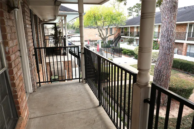 a view of a balcony with large trees