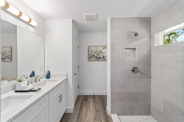 a bathroom with a double vanity sink mirror and shower