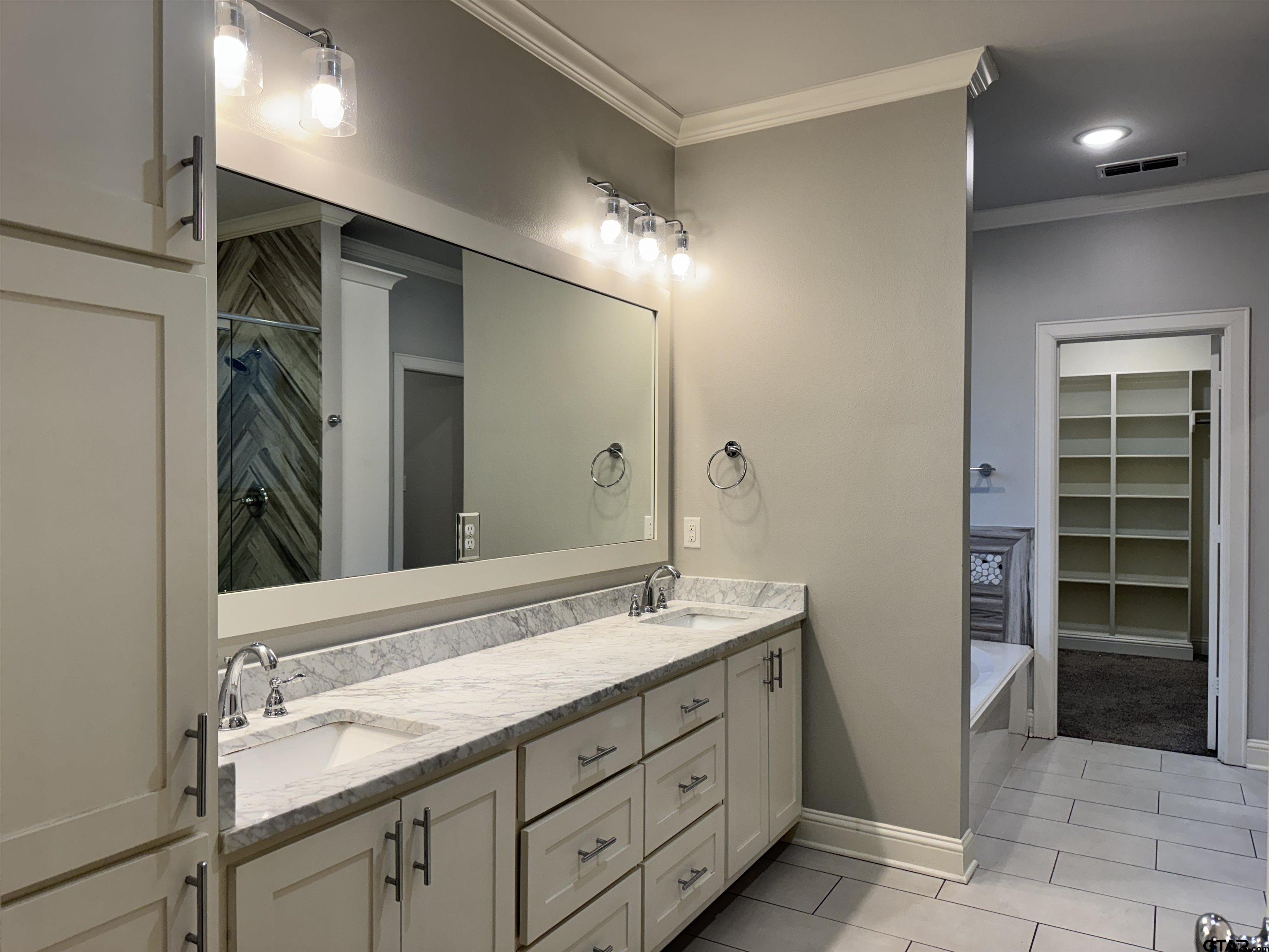 7315 Rolling Acres Place Tyler, TX 75707 - Photo 15 of 37 a spacious bathroom with a double vanity sink and a mirror