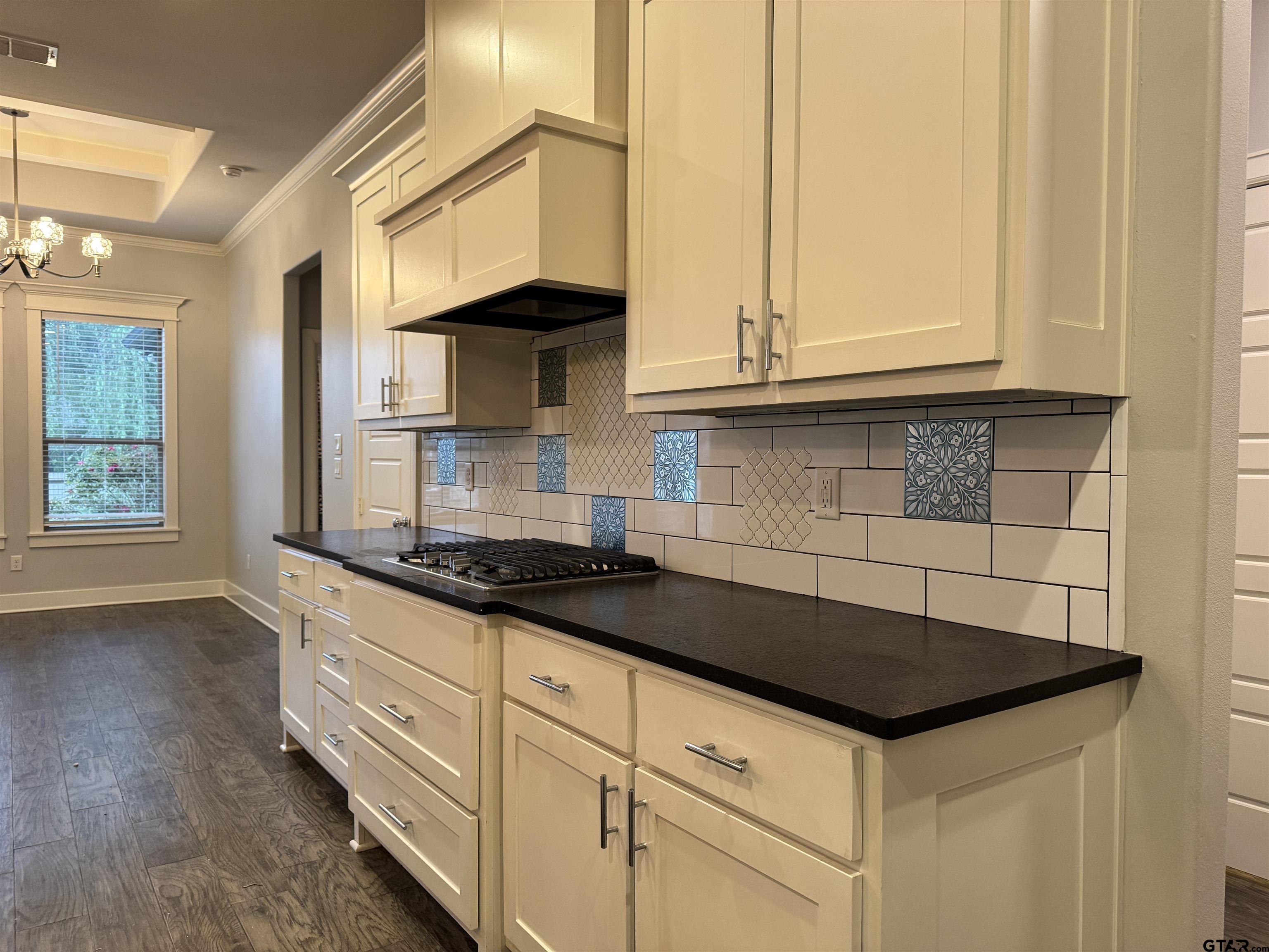 7315 Rolling Acres Place Tyler, TX 75707 - Photo 7 of 37 a kitchen with granite countertop a sink a stove and cabinets