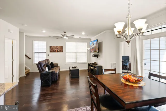 a view of a dining room with furniture a chandelier and wooden floor