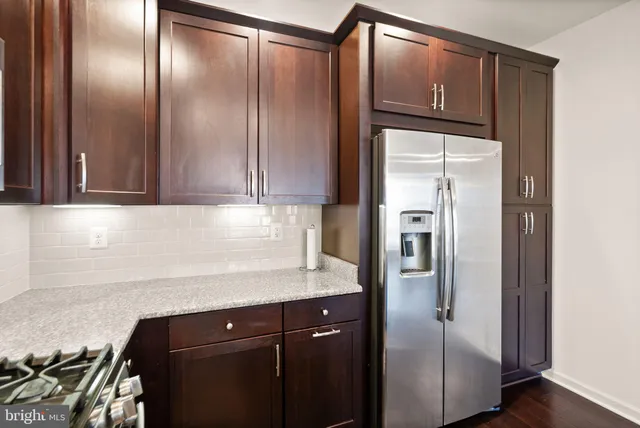 a kitchen with stainless steel appliances granite countertop a refrigerator and a sink