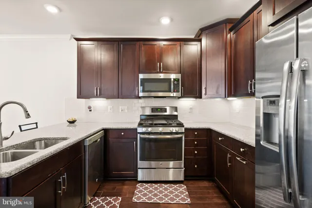 a kitchen with stainless steel appliances granite countertop a stove a sink and a refrigerator