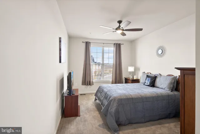 a bedroom with a large bed and a ceiling fan