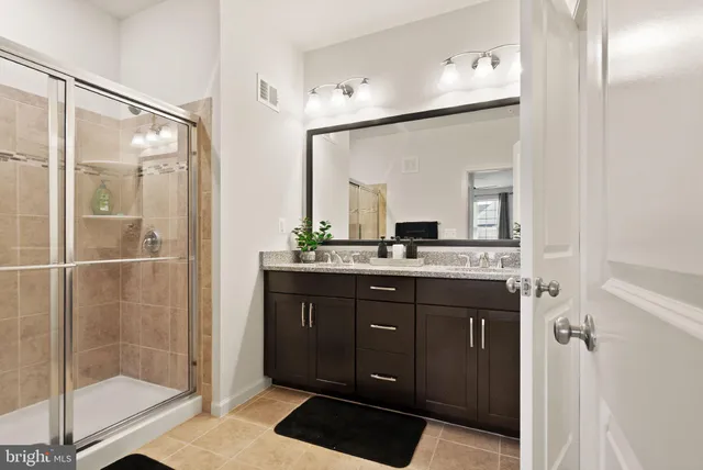 a bathroom with a shower sink and mirror