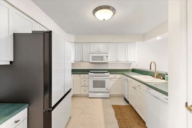 a view of a livingroom with a fireplace a sink and a window