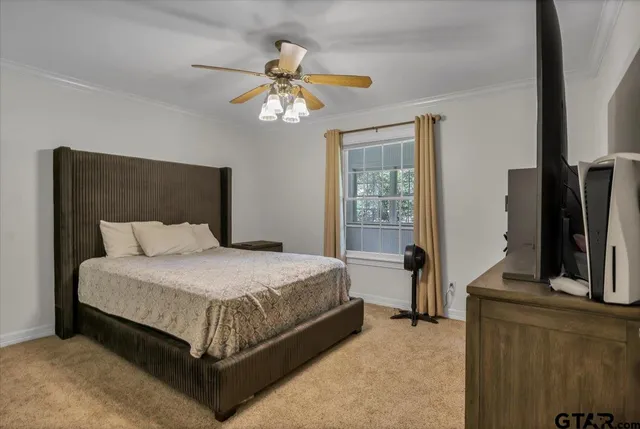a bedroom with a bed lamps and a large mirror on the dresser