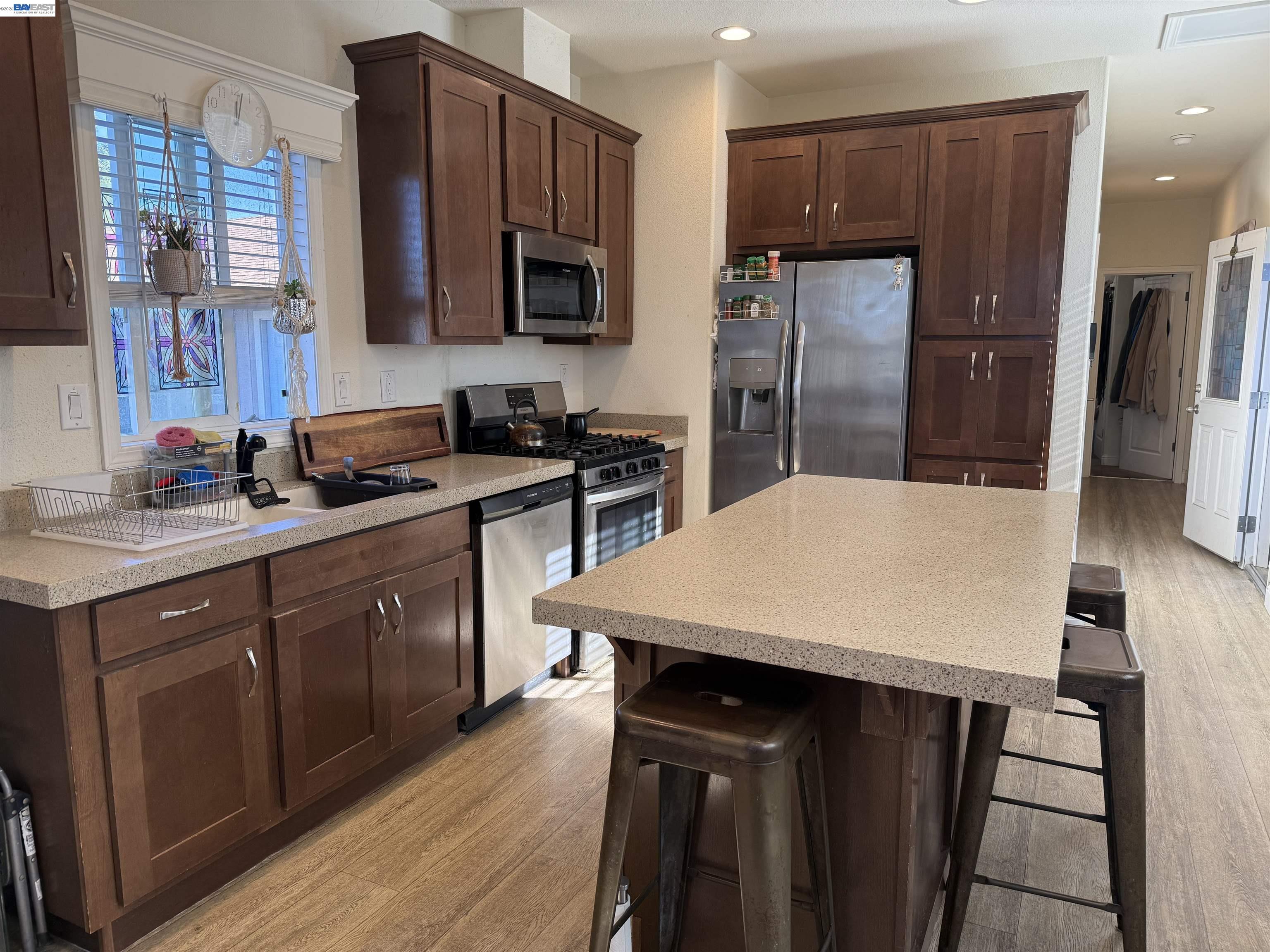 1161 Benicia Road, Unit 21 Vallejo, CA 94591 - Photo 6 of 14 a kitchen with stainless steel appliances kitchen island a table chairs microwave and refrigerator
