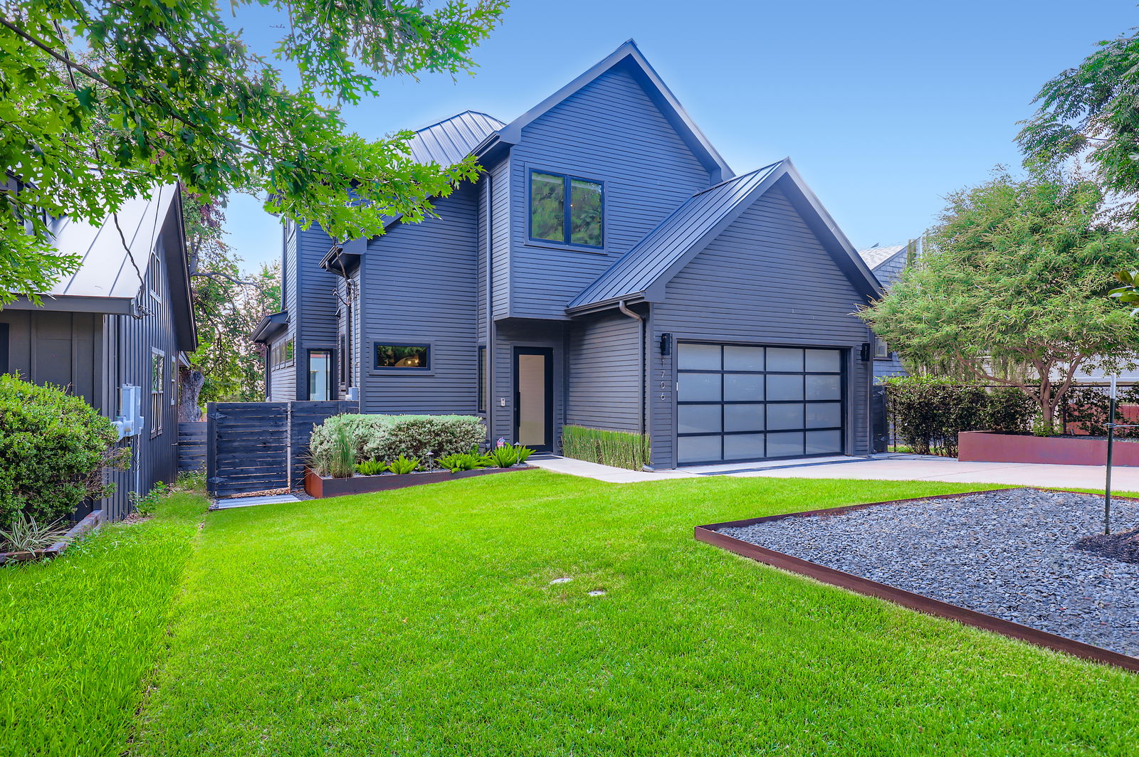 1706 Hartford Road Austin, TX 78703 - Photo 1 of 1 View of front of home with a metal roof, a garage, a standing seam roof, and driveway
