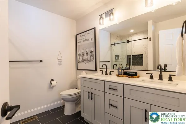 a bathroom with a toilet sink a mirror and shower