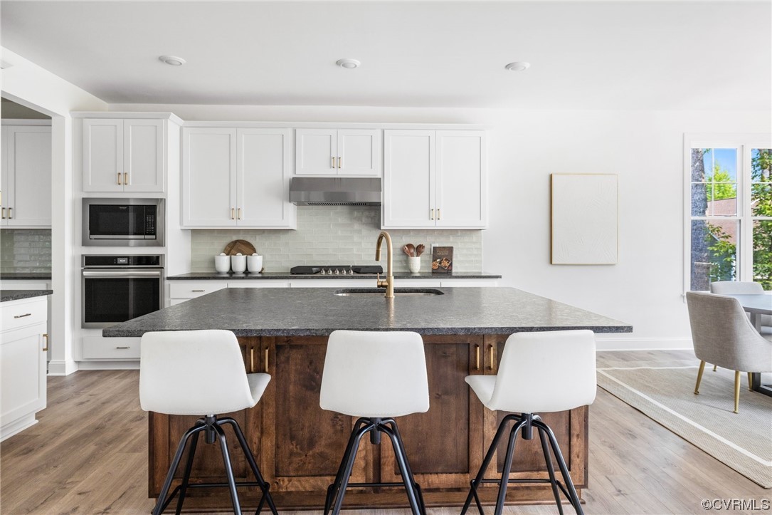 8357 Capernwray Drive Chesterfield, VA 23838 - Photo 20 of 50 a kitchen with stainless steel appliances a dining table chairs microwave and sink