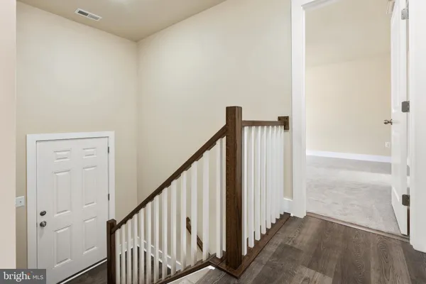 a view of a hallway with wooden floor and entryway