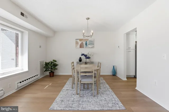 a view of a hallway with wooden floor and a living room