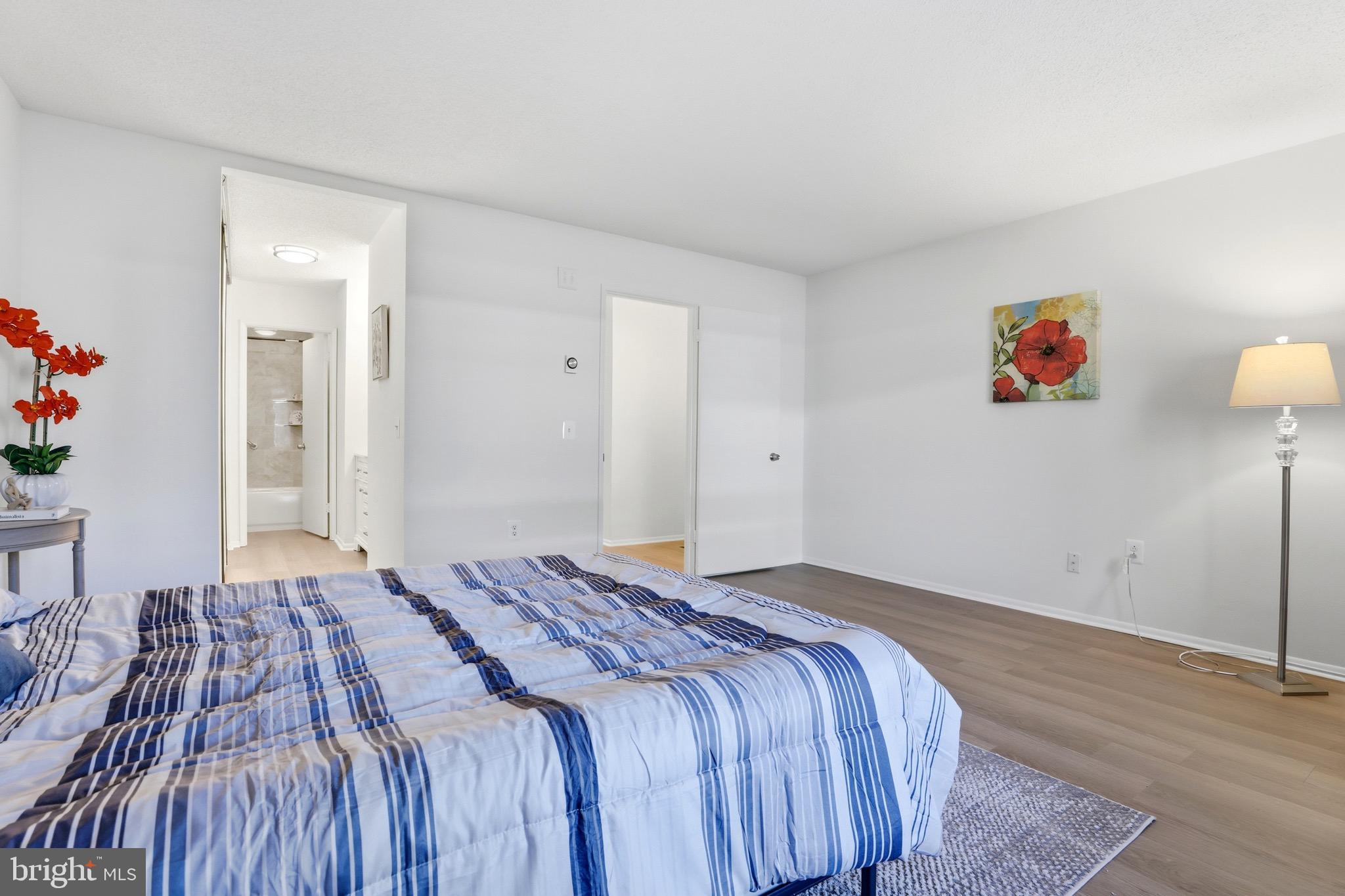 3500 Forest Edge Drive, Unit 152F Silver Spring, MD 20906 - Photo 25 of 31 a bedroom with a bed and a painting on the wall