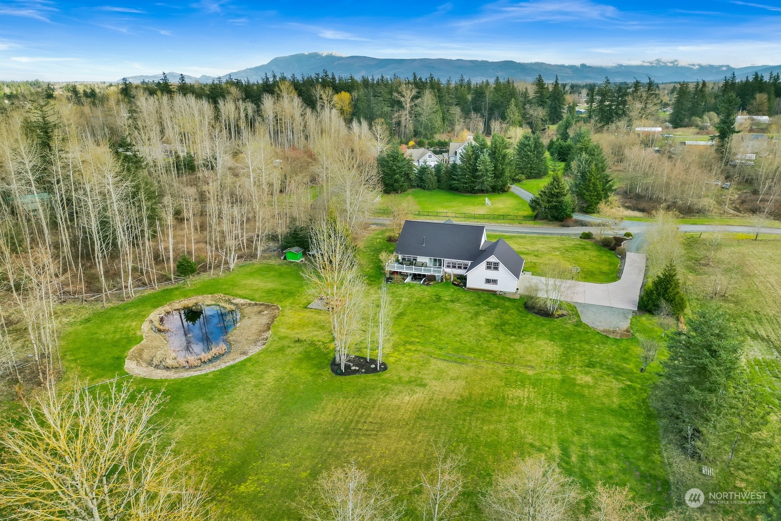 5747 Silverstar Road Bellingham, WA 98226 - Photo 3 of 40 a view of a lake with a yard and large trees