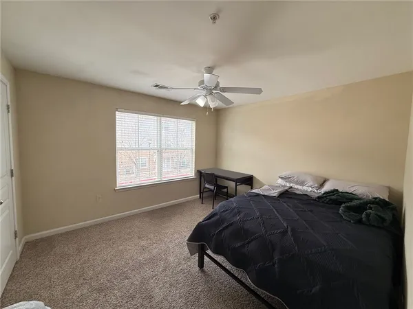 a spacious bedroom with a bed and a flat screen tv