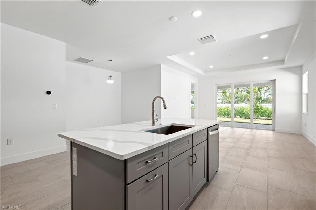 8897 Oceana Way Naples, FL 34114 - Photo 5 of 40 Kitchen island with stainless steel farmhouse sink and pull-down faucet