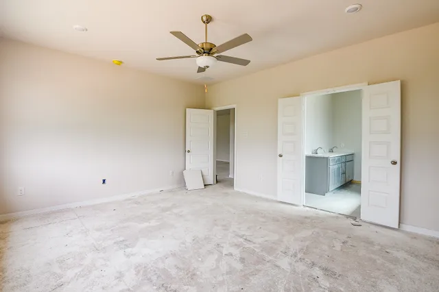 a view of a livingroom with a ceiling fan and a bathroom