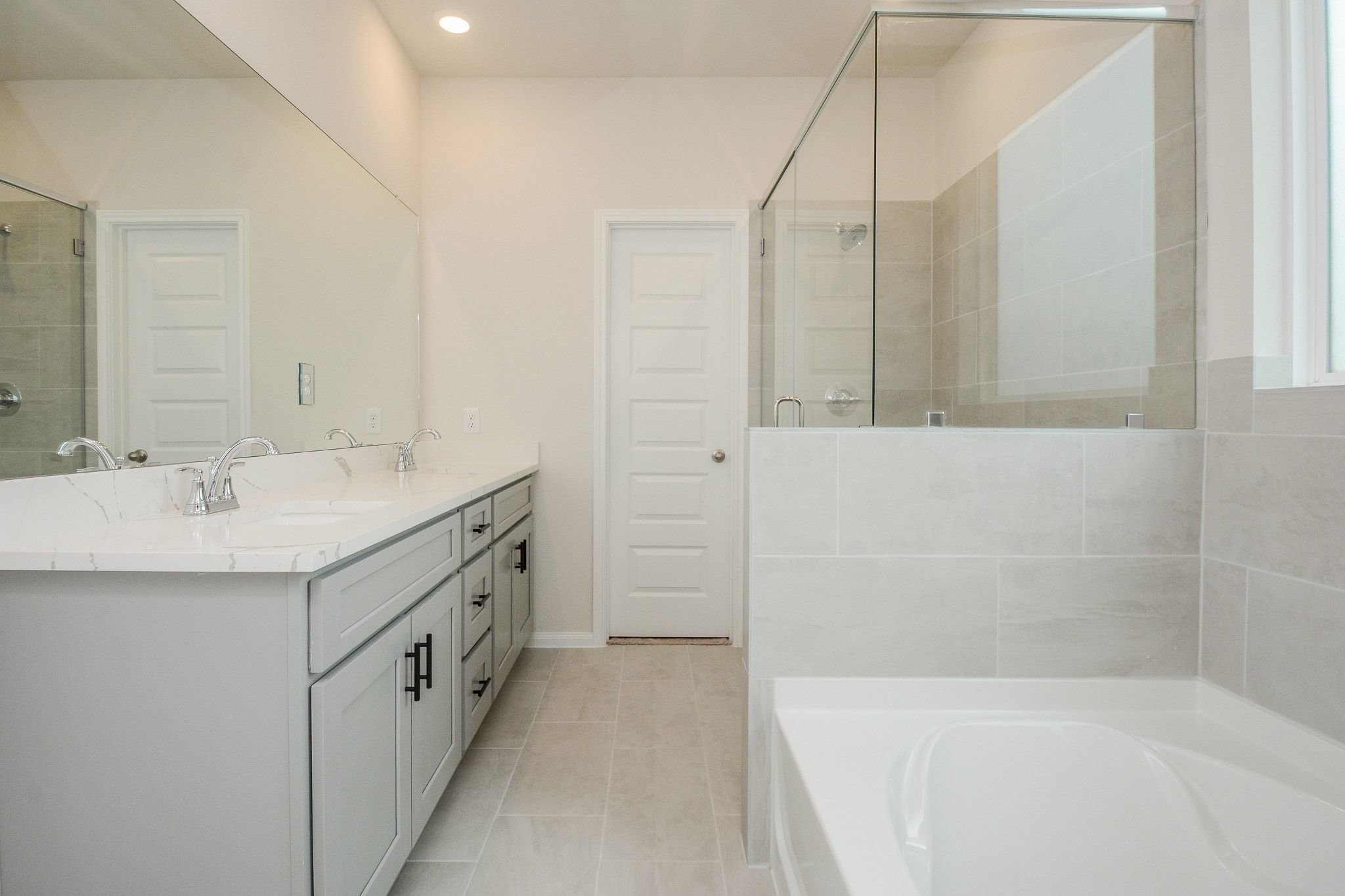 20629 Dynamic Court Humble, TX 77338 - Photo 28 of 36 a bathroom with a double vanity sink a mirror and a bathtub
