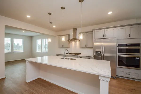 a large kitchen with stainless steel appliances a large counter top oven and cabinets